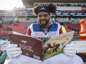 Montreal Alouettes defensive-tackle Woody Baron poses with his children's book on the sidelines in Toronto on Oct. 20, 2018.