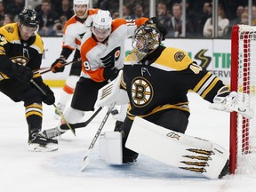 Bruins' John Moore (27) and Flyers' Nolan Patrick (19) battle for the puck in front of Bruins' Jaroslav Halak Thursday night in Boston.