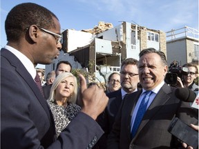 Quebec Premier François Legault along with Gatineau Mayor Maxime Pedneaud-Jobin, centre, listen as federal Liberal M.P.for Hull-Aylmer, Greg Fergus, left, explains some details of the damage caused by a tornado last month in Gatineau, Friday, October 19, 2018.