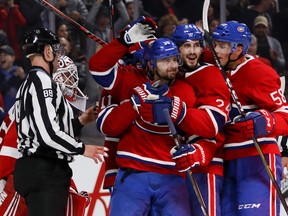 Phillip Danault, centre, Tomas Tatar and Noah Juulsen, right, celebrate Danault's goal against the Red Wings in Montreal on Monday Oct. 15, 2018.