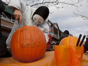 A scarrrry skeleton stabs a pumpkin in a pumpkin carving contest at halloween party in Beaconsfield.