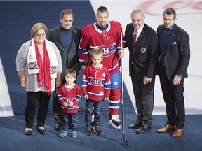 The Canadiens' Tomas Plekanec poses with his two young sons and his mother, along with Canadiens owner/president Geoff Molson and GM Marc Bergevin and Hall of Famer Guy Lafleur after being presented with a silver stick at the Bell Centre on Oct. 17, 2018 to honour him playing in 1,000 NHL regular-season games.