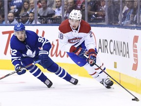 Montreal Canadiens defenceman Mike Reilly (28) carries the puck as Toronto Maple Leafs defenceman Igor Ozhiganov (92) defends during first period NHL hockey action in Toronto on Wednesday, October 3, 2018.