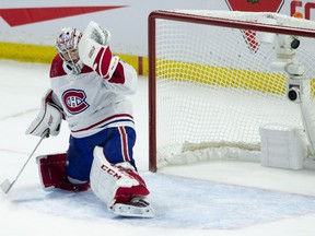 The puck deflects off the cross bar on a shot from Senators' Mark Stone, not shown, past Canadiens goalie Carey Price during overtime in Ottawa on Saturday, Oct. 20, 2018.