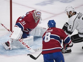 Canadiens goaltender Carey Price makes a save against Los Angeles Kings' Jake Muzzin as Canadiens' Jordie Benn defends in Montreal, Thursday, Oct. 11, 2018.