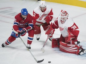 Montreal Canadiens' Tomas Tatar (90) moves in on Detroit Red Wings goaltender Jimmy Howard as Red Wings' Nick Jensen defends during second period NHL hockey action in Montreal, Monday, October 15, 2018.