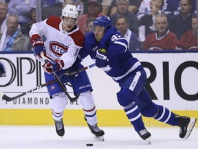 Toronto Maple Leafs Igor Ozhiganov checks Montreal Canadiens' Jesperi Kotkaniemi during the second period in Toronto on Oct. 3, 2018.