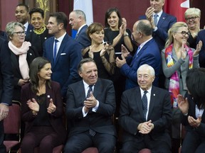 Quebec Premier François Legault, centre, celebrates with his new cabinet and Quebec Lt.-Gov. J. Michel Doyon, right, after he and his cabinet were sworn in during a ceremony at the National Assembly on Thursday.
