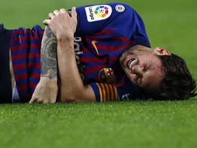 FC Barcelona's Lionel Messi lies on the ground holding his arm during Spanish La Liga action against Sevilla at the Camp Nou stadium in Barcelona, Spain, Saturday, Oct. 20, 2018.