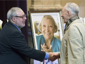 Daniel Payette, left, is greeted by a man during a memorial service for Lise Payette at city hall in Montreal on Saturday, Oct. 20, 2018.