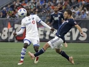 Montreal Impact's Michael Azira, left, and New England Revolution's Kelyn Rowe vie for control of the ball during the first period of an MLS soccer game on Sunday, Oct. 28, 2018, in Foxborough, Mass.