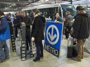 People wait in line to buy old métro signs and other items during an STM garage sale in Montreal Oct. 14, 2018.