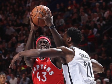 Toronto Raptors forward Pascal Siakam mixes it up with Brooklyn Nets guard Treveon Graham during first-half NBA pre-season game in Montreal on Wednesday, Oct. 10, 2018.