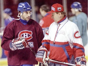 Defenceman Mathieu Schneider chats with coach Jacques Demers before the start of practice at the Forum in Montreal on March 6, 1995.