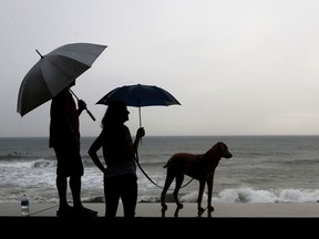 A couple and their dog stand of the seawall prior the landfall of Hurricane Willa in Mexico Oct. 23.