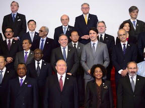 Prime Minister Justin Trudeau, middle, stands beside Quebec premier-designate François Legault as they take part in a family photo at the Francophonie Summit in Yerevan, Armenia on Thursday, Oct. 11, 2018.