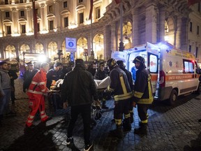 Firefighters evacuate a person who was wounded after an escalator at the "Repubblica" subway station in Rome, started running much too fast before crashing, Tuesday, Oct. 23, 2018. According to first reports many of the people wounded in the accident were fans of CSKA Moscow, who were in Rome for tonight's Champions League match with Roma.