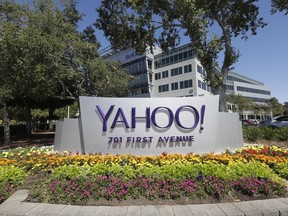 In this July 19, 2016, file photo, flowers bloom in front of a Yahoo sign at the company's headquarters in Sunnyvale, Calif. Yahoo has agreed to pay $50 million in damages and provide two years of free credit-monitoring services to about 200 million people in the U.S. and Israel whose email addresses and other personal information were stolen as part of the biggest security breach in history.