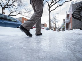 MONTREAL, QUE.: JANUARY 5, 2015 -- A pedestrian walks on an icy sidewalk on Drolet street near the corner of Villeray street in Montreal the day after an ice storm hit parts of Quebec on Monday, January 5, 2015.