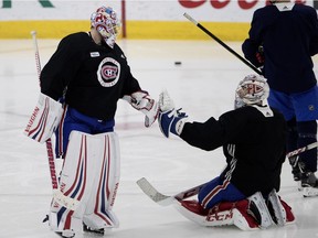 Canadiens goaltender Antti Niemi taps gloves with Carey Price as they take turns between the pipes during a team practice in Montreal on  Sept. 25, 2018.