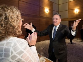 François Legault greets Marguerite Blais as he enters a meeting to address CAQ candidates on Oct. 3. Blais, the government's minister for seniors, is one of the few CAQ ministers with previous experience at a cabinet table.