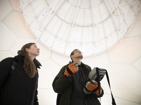Marie-Ève Giguère listens to meterological technician Jouni Makkonen as he uses remote control to operate the new weather-radar installation in Blainville on Thursday, Nov. 1, 2018.