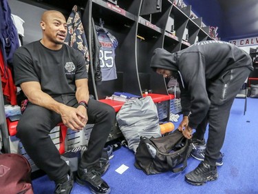 Alouettes' John Bowman sits at his stall as receiver B.J. Cunningham packs a bag as players cleaned out their lockers at the Olympic Stadium in Montreal on Sunday, Nov. 4, 2018.