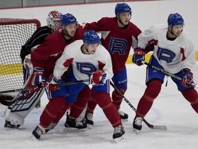 Laval Rocket goaltender Charlie Lindgren tries to follow the puck as he is crowded by teammates during a practice in Montreal on Nov. 6, 2018.