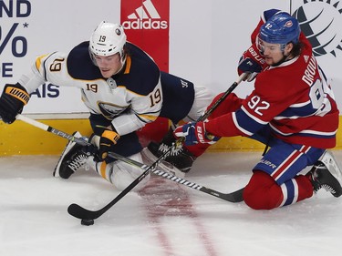 Jonathan Drouin pulls puck away from Buffalo Sabres' Jake McCabe as both fall to the ice during second period n Montreal on Thursday, Nov. 8, 2018.