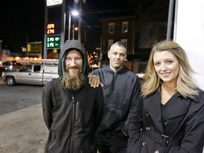 In this Nov. 17, 2017, file photo, Johnny Bobbitt Jr., left, Kate McClure, right, and McClure's boyfriend Mark D'Amico pose at a Citgo station in Philadelphia. A New Jersey prosecutor was set to announce developments Thursday, Nov. 15, 2018, in a criminal investigation of the couple that raised $400,000 for Bobbitt Jr, a homeless man they said helped them with a disabled car.