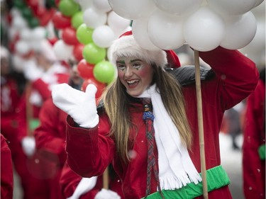 A participant is all smiles toward the kids as she  takes part in the Santa Claus Parade along Ste-Catherine St. in Montreal on Saturday, Nov. 17, 2018.