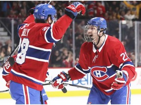 Montreal Canadiens' Mike Reilly, left, celebrates his  first period goal against the Washington Capitals with Nicolas Deslauriers  in Montreal on Nov. 19, 2018.