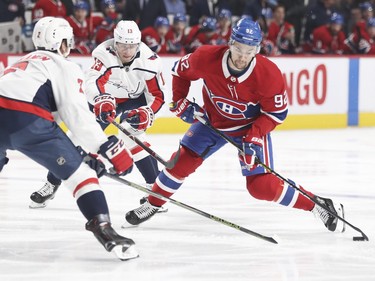 Jonathan Drouin takes a shot while being defended against by Washington Capitals' Matt Niskanen, left, and Jakub Vrana during first period at the Bell Centre on Monday, Nov. 19, 2018.