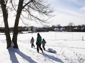 A family enjoys the snow at the soccer field across from Lindsay Place High School in Pointe-Claire. The field is being zoned as a permanent green space.