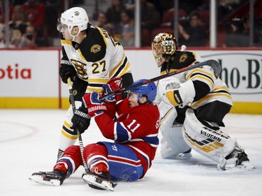 Boston Bruins defenceman John Moore knocks Canadiens' Brendan Gallagher to the ice as Bruins goaltender Tuukka Rask follows the play in Montreal on Saturday, Nov. 24, 2018.