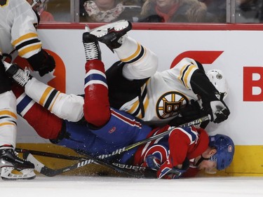 Boston Bruins defenceman Torey Krug jumps on Canadiens' Artturi Lehkonen driving his head in to the ice in Montreal on Saturday, Nov. 24, 2018.