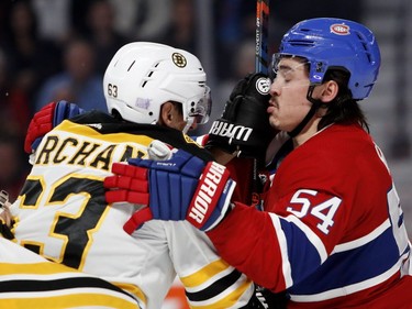 Canadiens'nCharles Hudon grimaces as Boston Bruins' Brad Marchand sticks his glove in Hudon's face in Montreal on Saturday, Nov. 24, 2018.