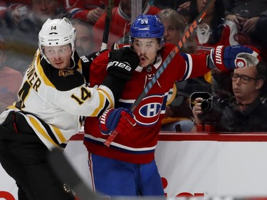 Canadiens' Charles Hudon reacts as Boston Bruins' Chris Wagner drives him into the boards in Montreal on Saturday, Nov. 24, 2018.