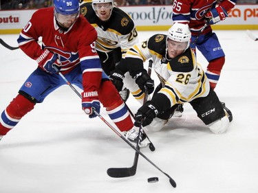 Canadiens' Tomas Tatar and Boston Bruins' Colby Cave battle for the puck after a face off in the final moments of the game in Montreal on Saturday, Nov. 24, 2018.