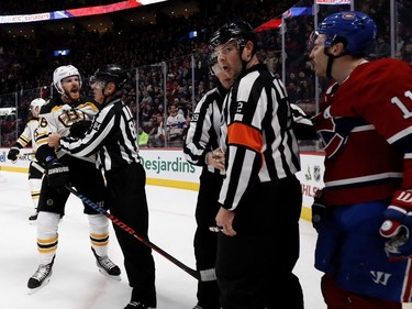 Three officials separate Boston Bruins defenceman Kevan Miller as he rages on Canadiens' Brendan Gallagher after the Canadiens scored against Bruins goaltender Tuukka Rask in Montreal on Saturday, Nov. 24, 2018.