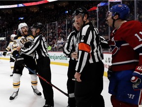 Officials separate Boston Bruins defenceman Kevan Miller as he rages on Canadiens forward Brendan Gallagher during NHL game at the Bell Centre in Montreal on Nov. 24, 2018.