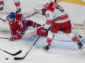 Canadiens defenceman Shea Weber watches as Hurricanes forward Warren Foegele tries to corral puck in front of the Montresl net.