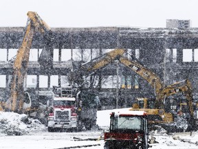 Demolition of buildings on the Royalmount site at the intersection of Highways 40 and 15 continues in the snow on Tuesday.