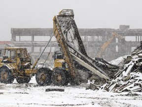 Scrap metal is dumped onto a pile as demolition of buildings on the site of the Royalmount mega mall at the intersection of Highways 40 and 15 continues.