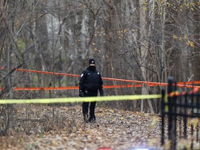 A Montreal Police officer stands near the spot in a wooded area where a body was discovered in Nun’s Island in Montreal Monday November 12, 2018. (John Mahoney / MONTREAL GAZETTE)