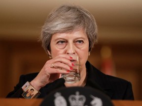 Britain's Prime Minister Theresa May takes a drink of water during a press conference inside 10 Downing Street in central London on November 15, 2018. - British Prime Minister Theresa May battled against a rebellion over her draft Brexit deal on Thursday, as ministers resigned and members of her own party plotted to oust her.