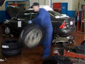 A worker rushes to install winter tires for latecomers as a huge early snowfall brought Montreal to a crawl on Dec. 3, 2007.