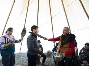 Canadian Prime Minister Justin Trudeau receives a water cleansing by spiritual leader Cecil Grinder along with Chiefs of the Tsilhqot'in National Government near Chilko Lake, British Columbia, Friday, Nov. 2, 2018.