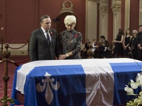 Quebec Premier Francois Legault and wife Isabelle Brais pay their respects at the casket of former Quebec premier Bernard Landry, lying in state at the National Assembly in Quebec City on Saturday.