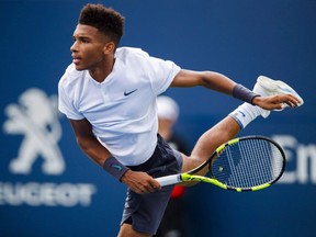 Montrealer Félix Auger-Aliassime serves to Lucas Pouill of France during the first round of the Rogers Cup tennis tournament in Toronto on Aug. 7, 2018.
